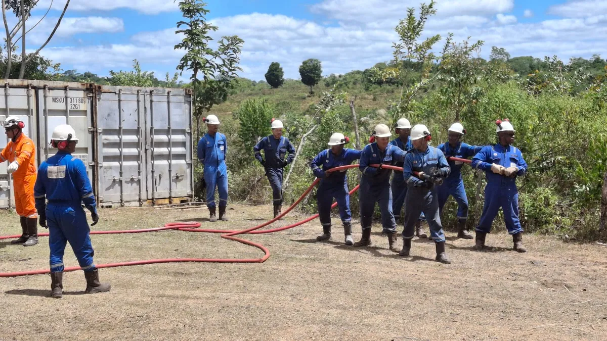 Jato de água sendo aplicado por equipe em simulado de incêndio